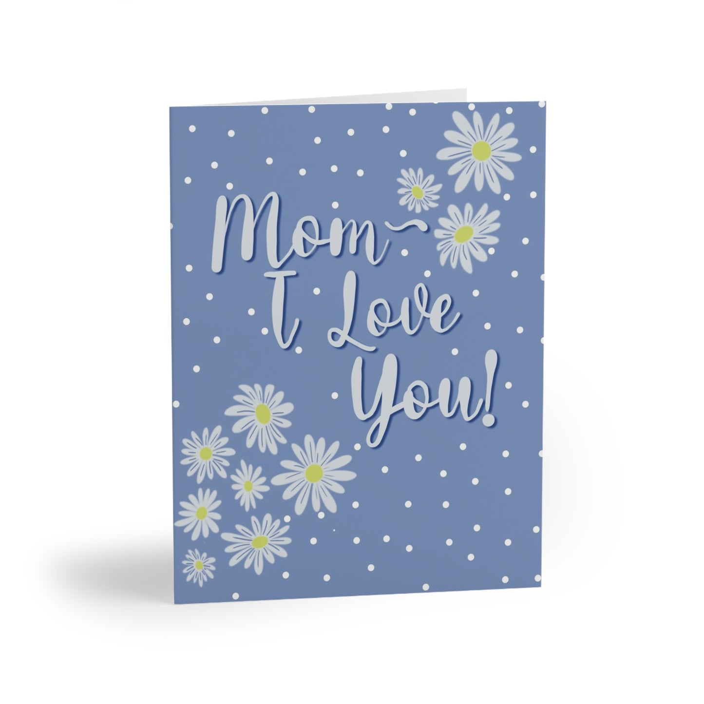 “A light blue card with white polka dots, white daisies with yellow centers, and the text "Mom I Love You!" in white script.”