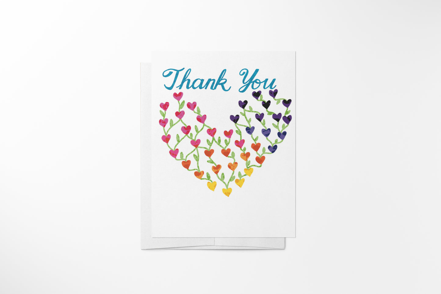 Hand-illustrated rainbow hearts thank you greeting card with white envelope on a clean background, by DeBell Designs.