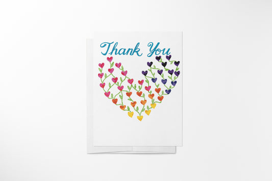 Hand-illustrated rainbow hearts thank you greeting card with white envelope on a clean background, by DeBell Designs.