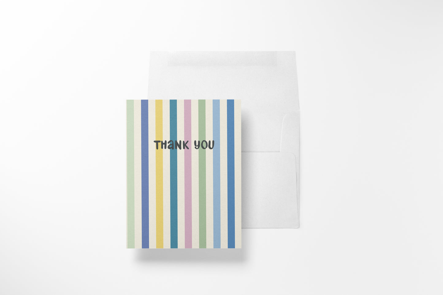A vertical striped thank you card with pastel vertical stripes in green, yellow, pink, blue, and white, with the words 'THANK YOU' printed in black. A plain white envelope is placed behind it on a clean white background.