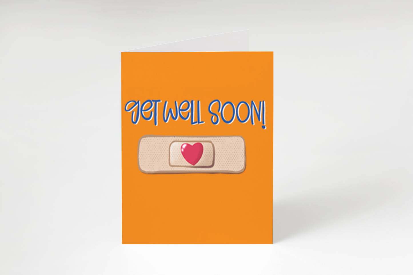 “A greeting card with an orange front, a bandaid graphic with a red heart in the center, and the phrase "GET WELL SOON!" in blue.”
