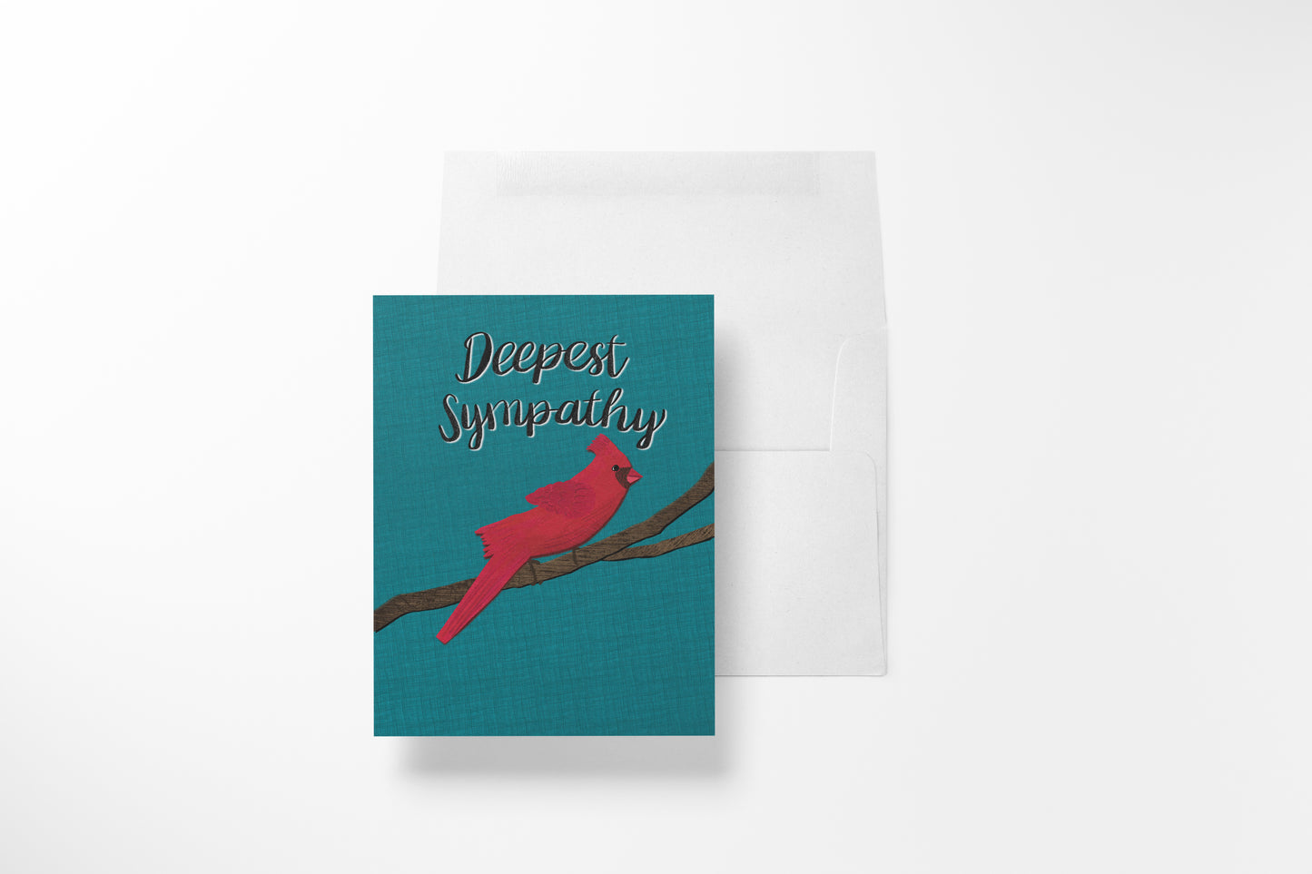 A greeting card with a teal background, a red cardinal perched on a branch, and the words 'Deepest Sympathy' in white script, shown with a white envelope behind it on a light gray background.